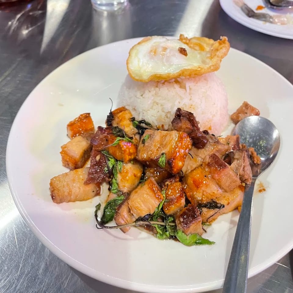 Crispy pork belly with basil and rice, topped with a fried egg, served at BOK BOK BABY BURIRAM.